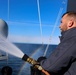 Electrician’s Mate 1st Class Kyle Allen conducts a fresh water wash down on the USS Bulkeley