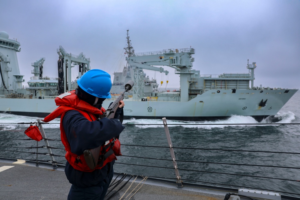 Gunner’s Mate Seaman Trinity Anderson discharges an M-14 rifle to send a phone and distance line to the Royal Canadian Navy replenishment oiler MV Asterix for an underway replenishment
