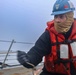 Navy Career Counselor 1st Class James McMillian heaves in a phone and distance line
