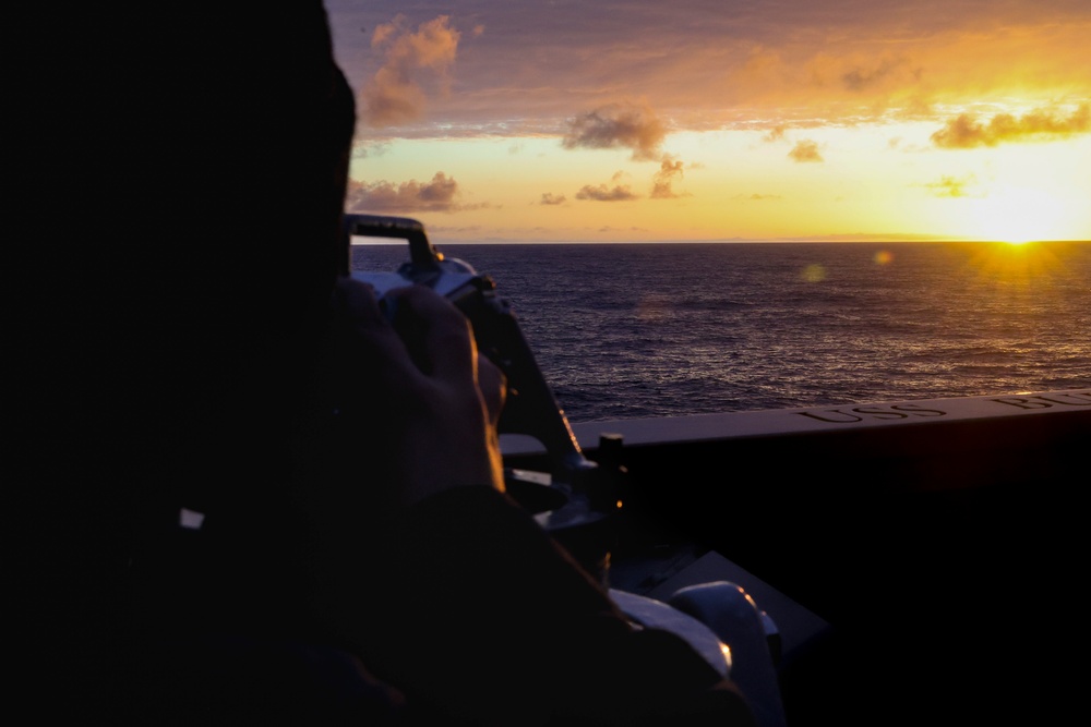 U.S. Navy Sailor takes a solar azimuth reading with a sextant