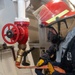 Damage Controlman 3rd Class Evan McDonald flakes out a firehose in response to a simulated fuel leak and class B fire exercise