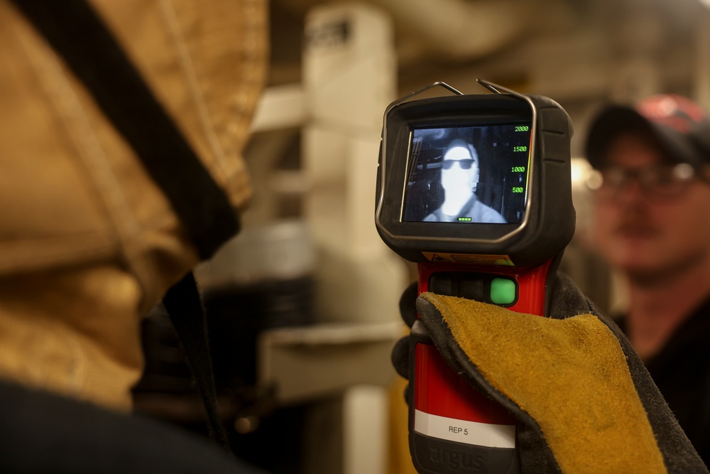 U.S. Navy Sailors demonstrate the functionality of the Naval Fire Fighter Thermal Imager (NFFTI)