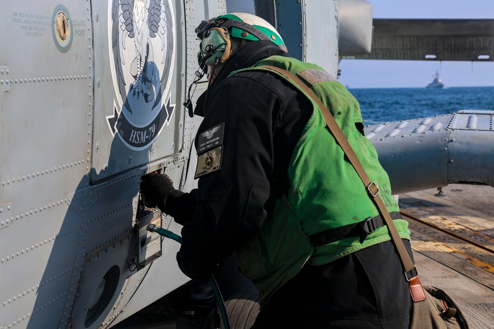 Aviation Technician 2nd Class Carlos Sanchez Mercado conducts a pre-flight check