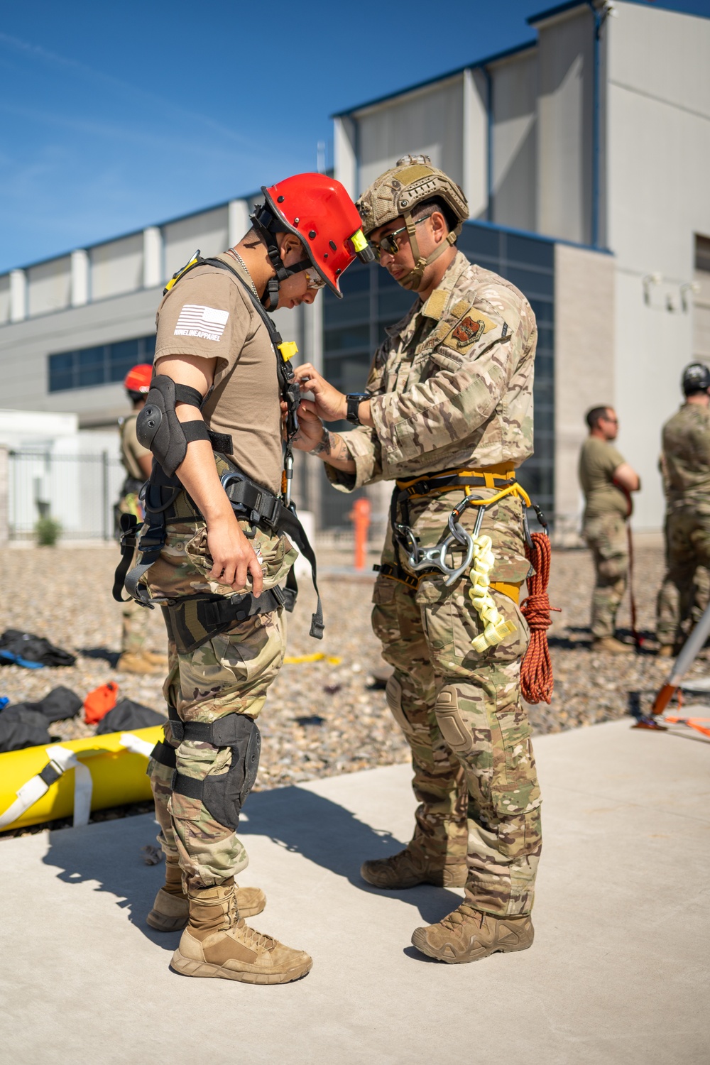 Airman assists Soldier with harness during joint training exercise