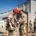 Airman assists Soldier with harness during joint training exercise