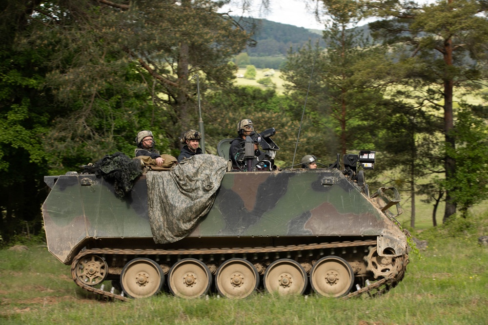 Opposing forces return simulated fire from a return fire from a M113 armored personnel carrier