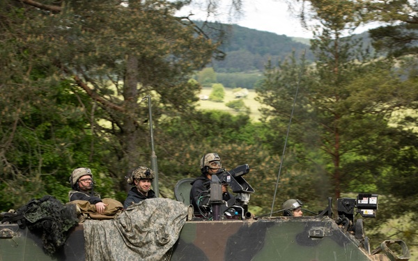 Opposing forces return simulated fire from a return fire from a M113 armored personnel carrier