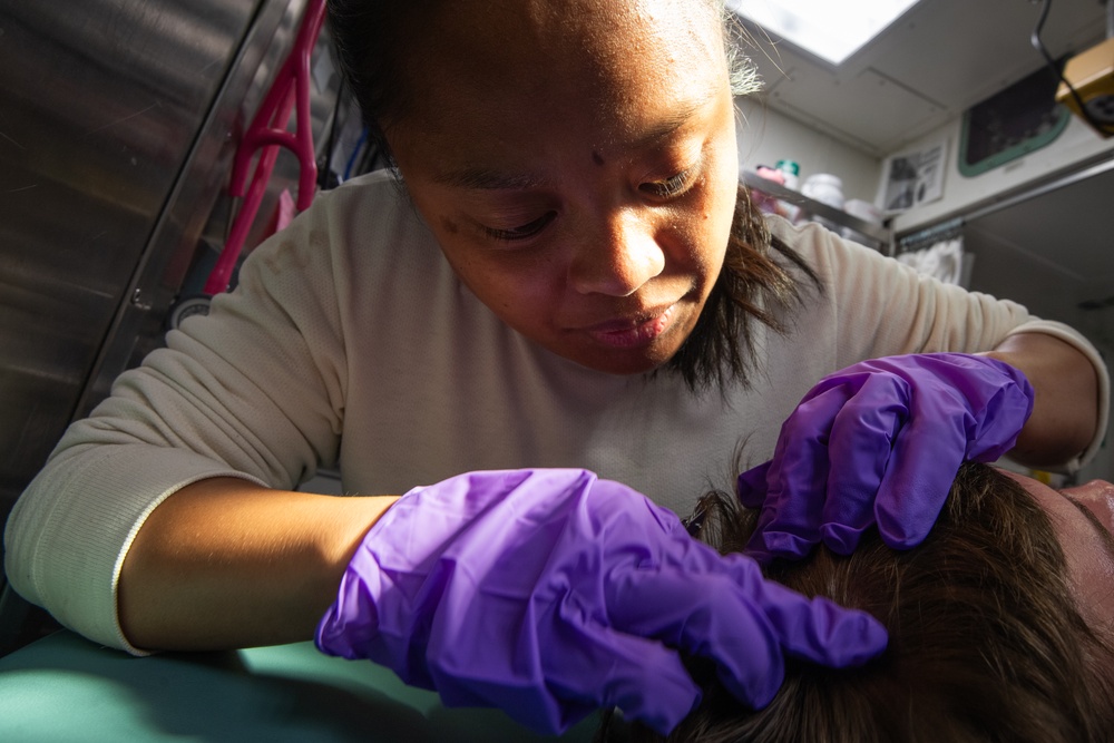 Hospital Corpsman Treats Head Wound
