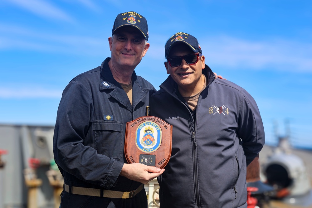 Capt. Michael Dwan, commodore, Combined Task Force (CTF) 64 receives a placard from Cmdr. Arturo Trejo
