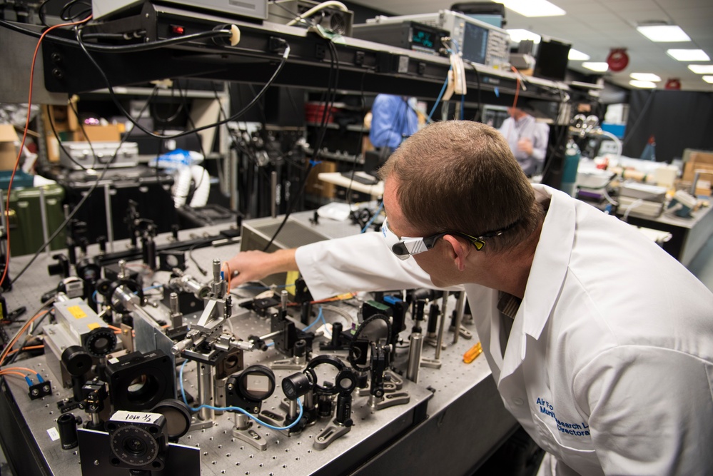 AFRL/RW scientist works on an experiment in a photonics laboratory