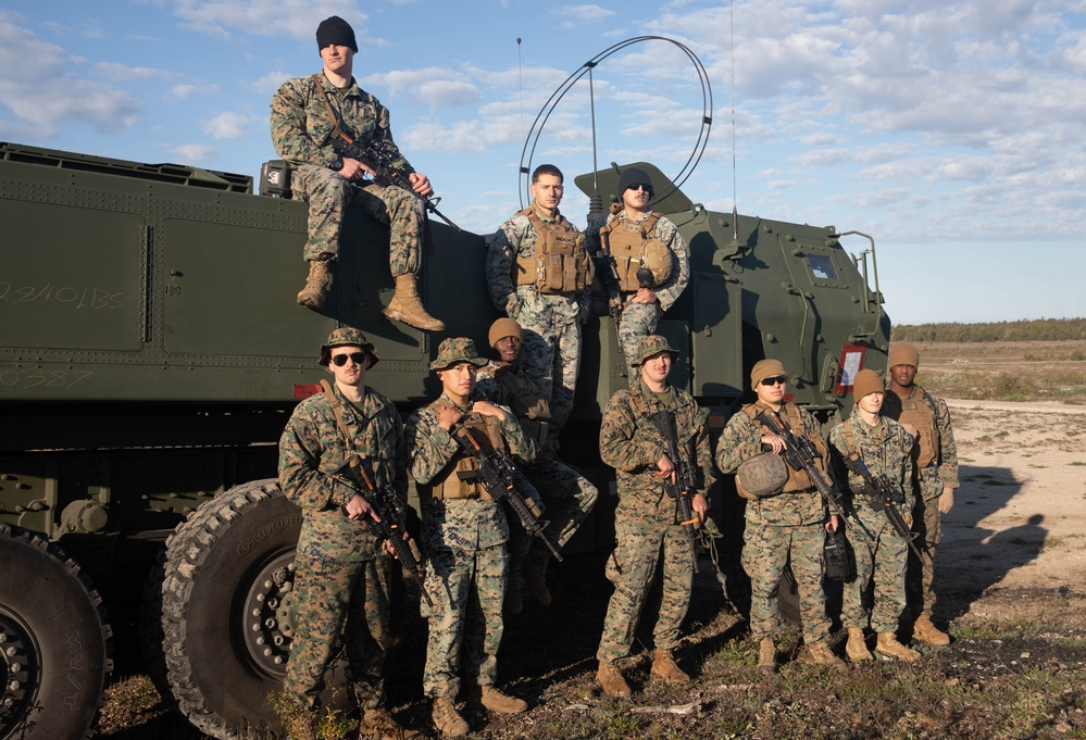 The Marines of Fox Batter 210 pose next to their High Mobility Artillery Rocket System (HIMARS) in Visby, Sweden