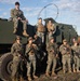 The Marines of Fox Batter 210 pose next to their High Mobility Artillery Rocket System (HIMARS) in Visby, Sweden