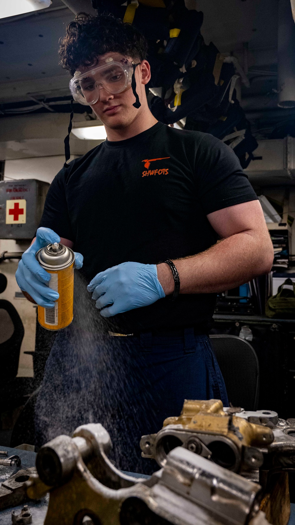 Nimitz Sailor Applies Cleaning Solution to Bomb Rack Components