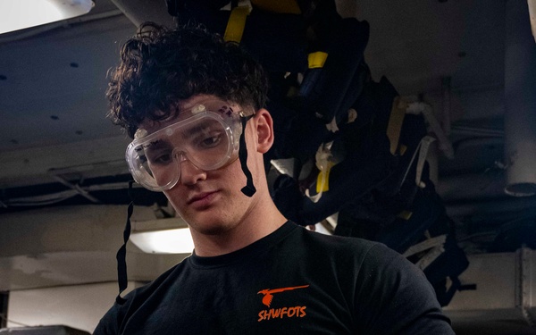 Nimitz Sailor Applies Cleaning Solution to Bomb Rack Components