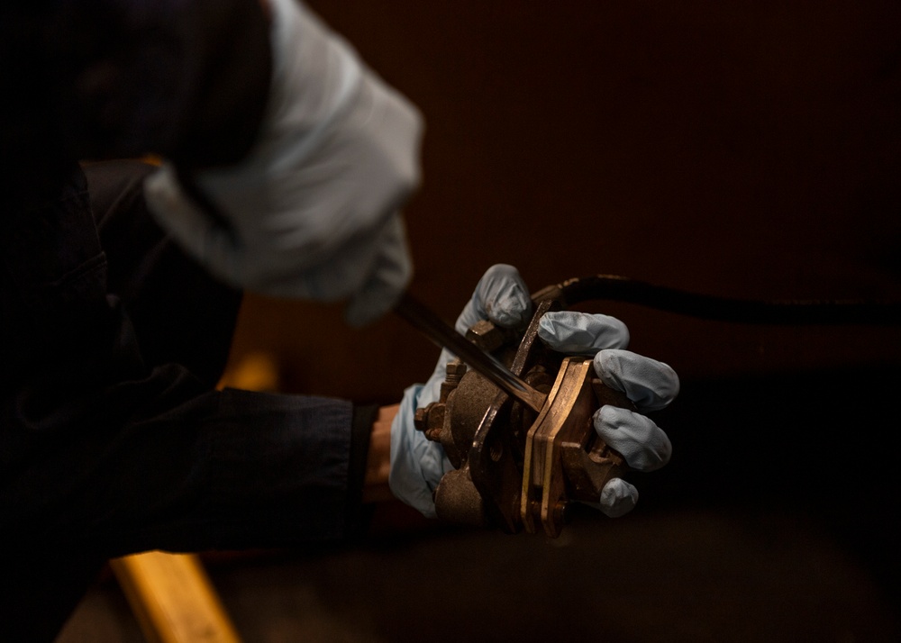 Sailor conducts maintenance on forklift