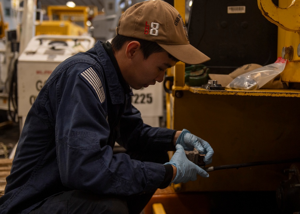 Sailor conducts maintenance on forklift