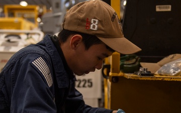 Sailor conducts maintenance on forklift