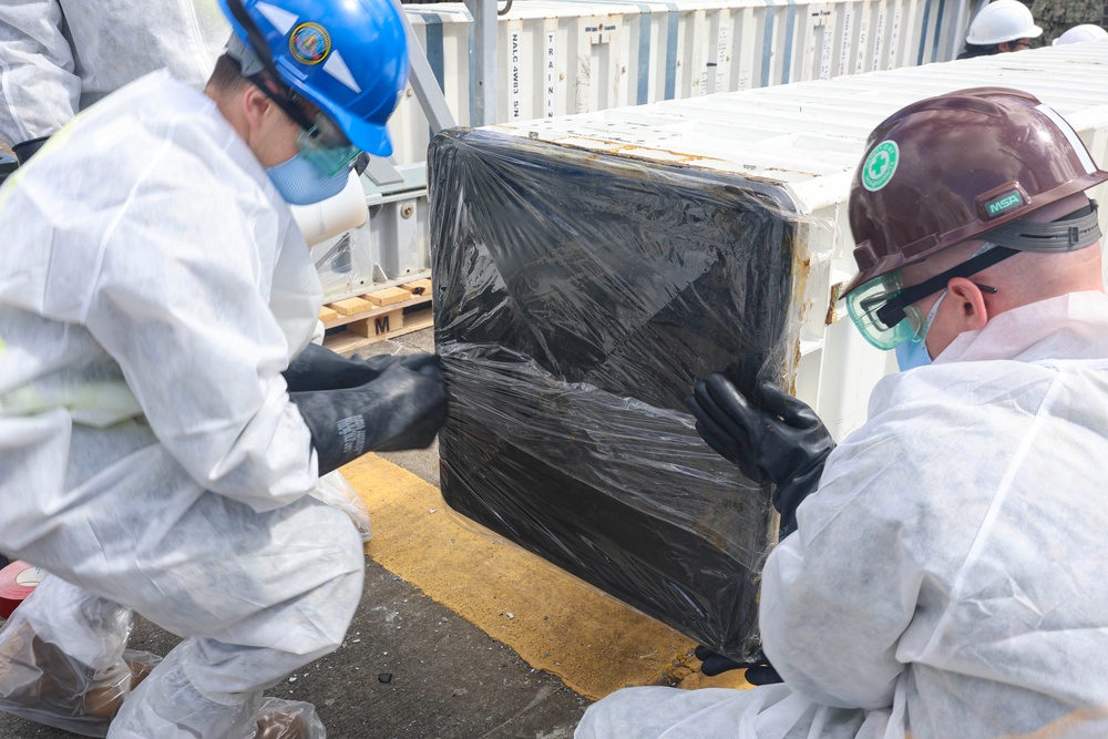 U.S. Navy Sailors re-seal and package a spent standard missile 3 cartridge out of a vertical launching system