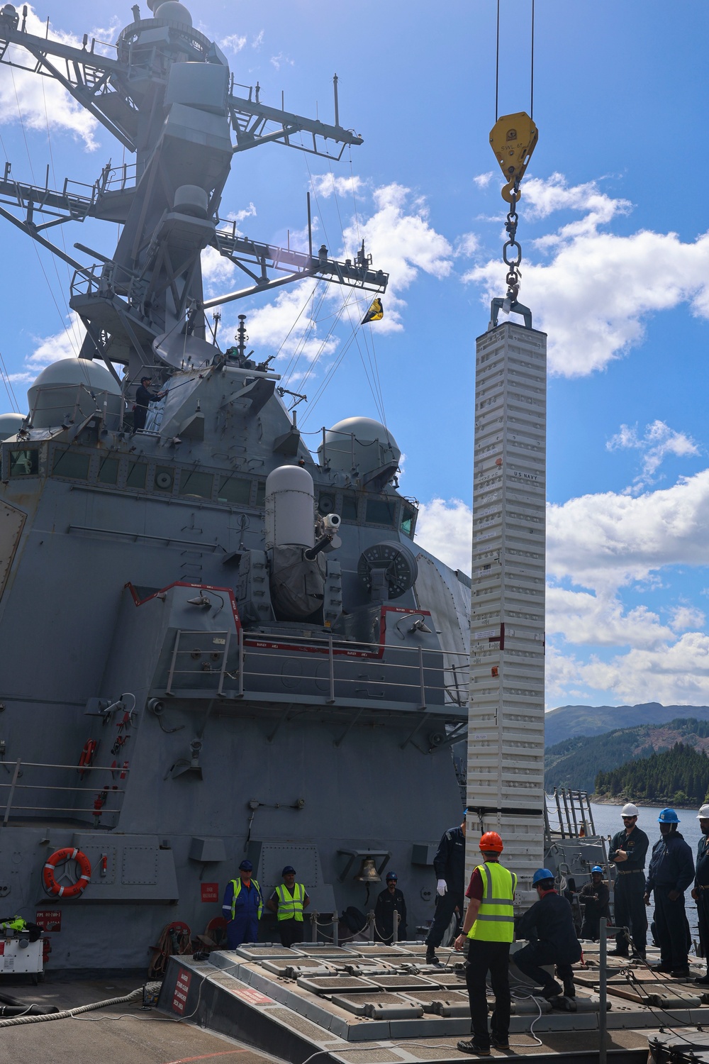 Sailors and contractors coordinate the reloading of a standard missile 3 and vertical launching system