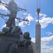 Sailors and contractors coordinate the reloading of a standard missile 3 and vertical launching system