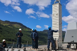 Crane operator lowers a vertical launching system to reload a standard missile 3