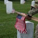 A Soldier from the 3d U.S. Infantry Regiment (The Old Guard) places American flags at headstones as part of &quot;Flags In&quot; at Arlington National Cemetery, Arlington, Va., May 22, 2025.