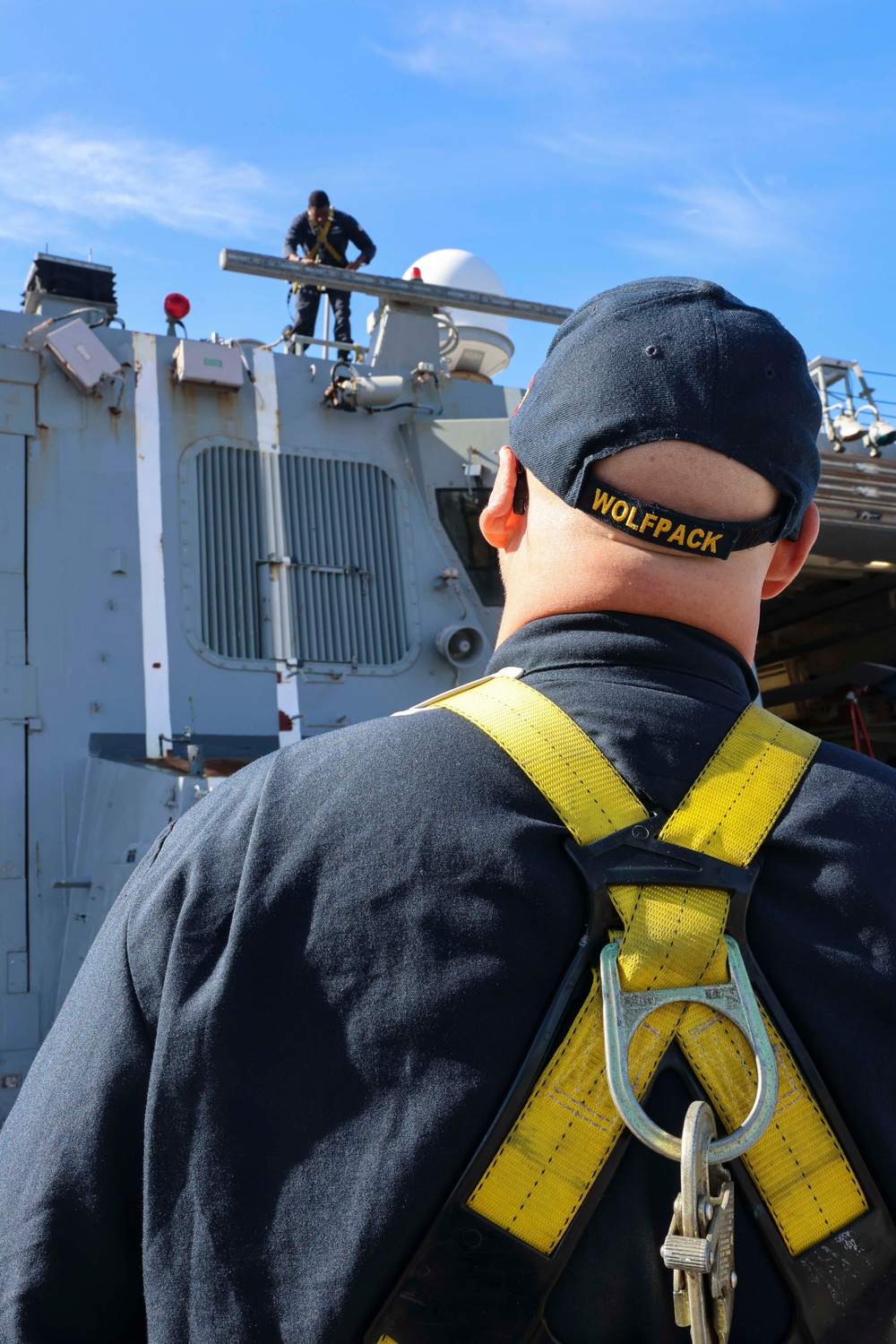 U.S. Navy Sailors prepare surfaces for preservation and painting while working aloft