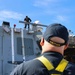 U.S. Navy Sailors prepare surfaces for preservation and painting while working aloft
