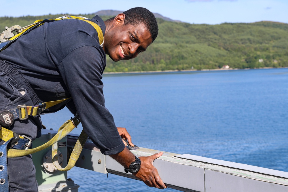Cryptologic Technician (Technical) 2nd Class Darren Grant prepares surfaces for preservation and painting
