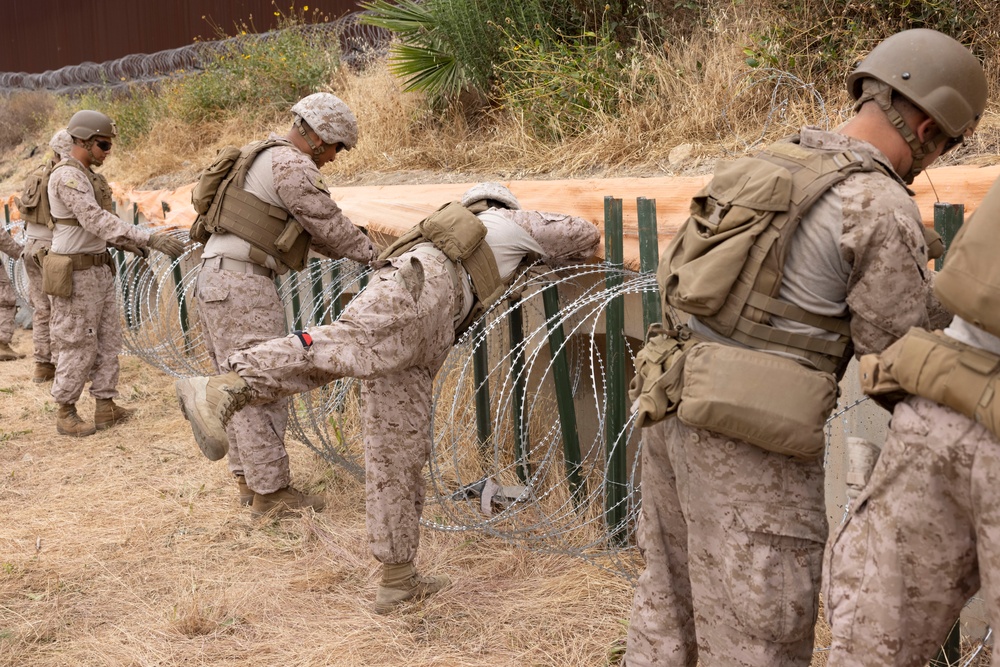U.S. Marines with Task Force Sapper adjust concertina wire