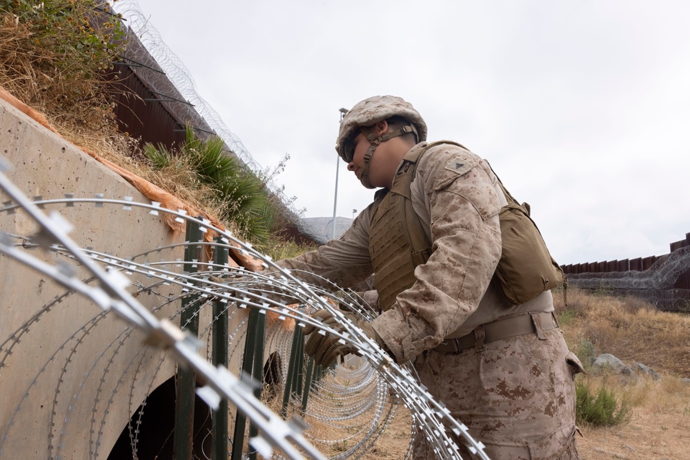 U.S. Marines with Task Force Sapper adjust concertina wire