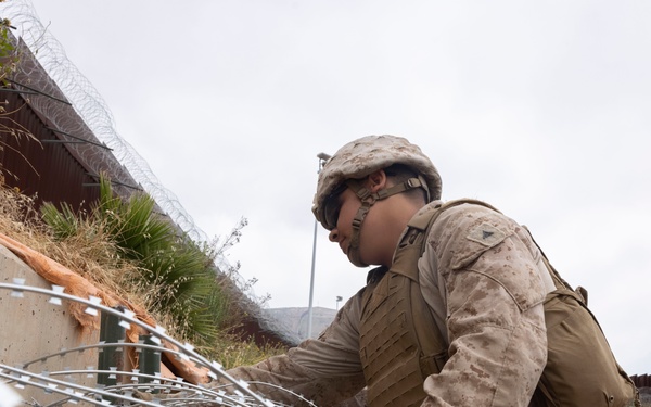 U.S. Marines with Task Force Sapper adjust concertina wire
