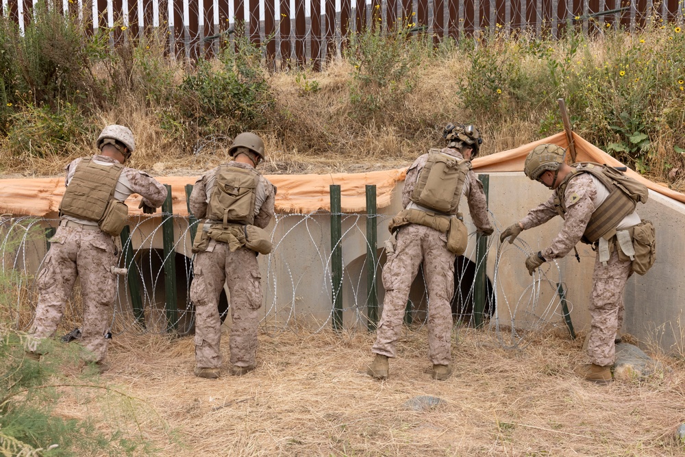 U.S. Marines with Task Force Sapper adjust concertina wire
