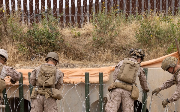 U.S. Marines with Task Force Sapper adjust concertina wire