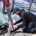 Fire Controlman 2nd Class Jalen Ross  installs the aft flag staff to the flight deck