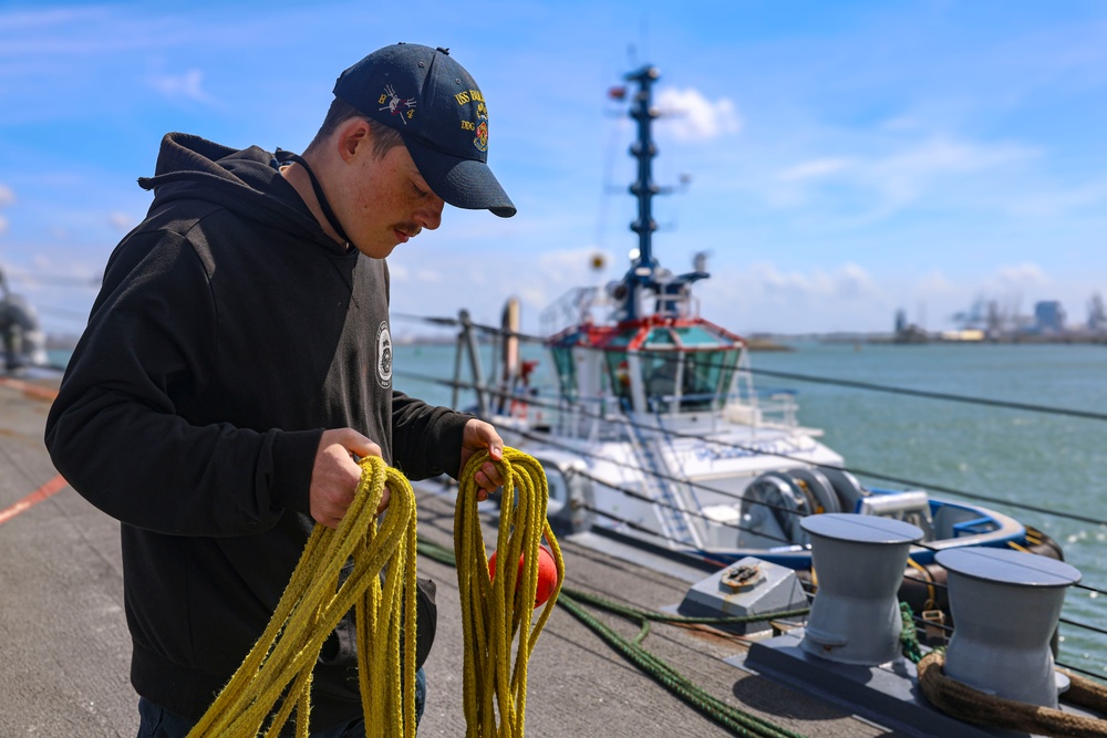 Boatswain’s Mate 3rd Class Johnathon Reynolds prepares to throw a mooring line to an approaching tug boat