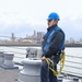 Boatswain’s Mate 3rd Class James Mark Monje prepares to lower the jack staff
