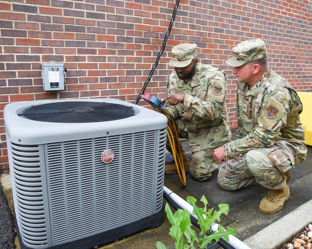 HVAC technicians perform check of AC unit