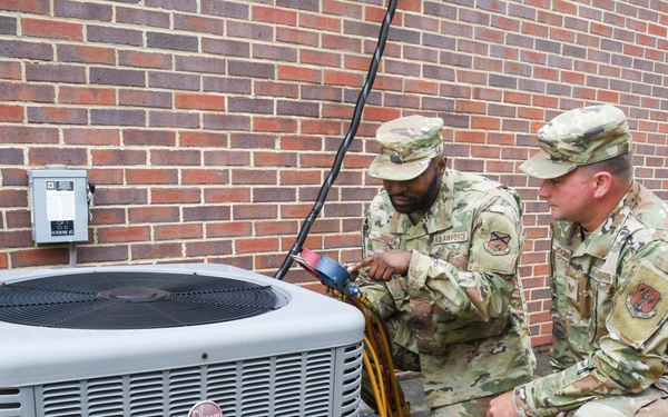 HVAC technicians perform check of AC unit