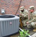 HVAC technicians perform check of AC unit