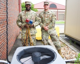 HVAC technicians perform check of AC unit