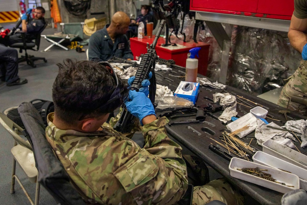 A U.S. Coast Guard Law Enforcement Detachment conducts weapons maintenance with U.S. Navy Sailors onboard the USS Charleston