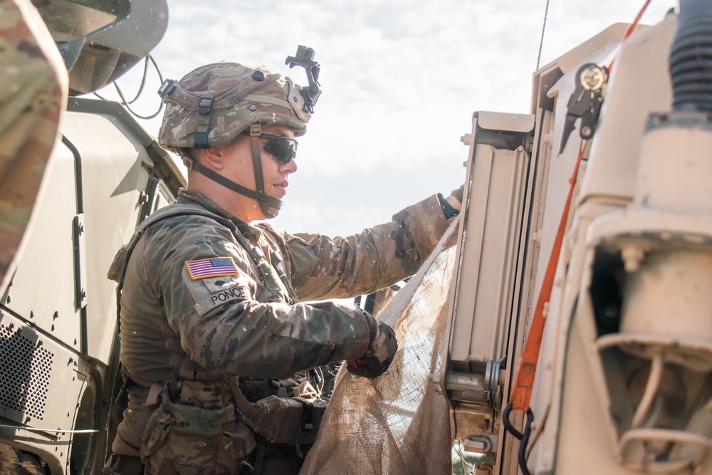 Iowa Army National Guard Soldier installs camouflage netting