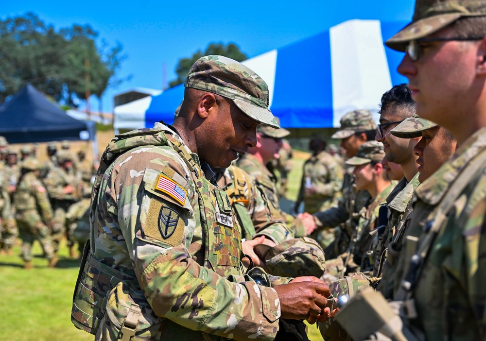 Command Sgt. Maj. Gregory Betty conducts patching ceremony following a mass re-enlistment at Fort Hunter Liggett