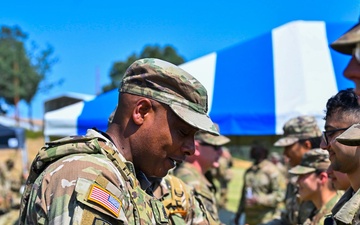Command Sgt. Maj. Gregory Betty conducts patching ceremony following a mass re-enlistment at Fort Hunter Liggett