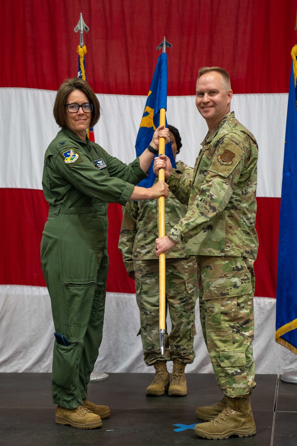 Chief Master Sgt. Jeffrey Linton, 152nd Airlift Wing Command Chief, passes the guidon for the final time to Col. Catherine Grush, Commander, 152nd Airlift Wing