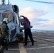GSM2 Mark Bacca presents a fuel sample to the MH-60R Sea Hawk helicopter pilot