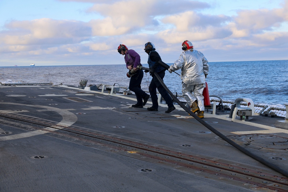 GSM2 Mark Bacca and DC3 Asia Taylor transport the fueling hose to a MH-60R Sea Hawk helicopter to re-fuel