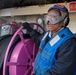 BM3 Sanaa Cooks unspools the re-fueling hose for a MH-60R Sea Hawk helicopter