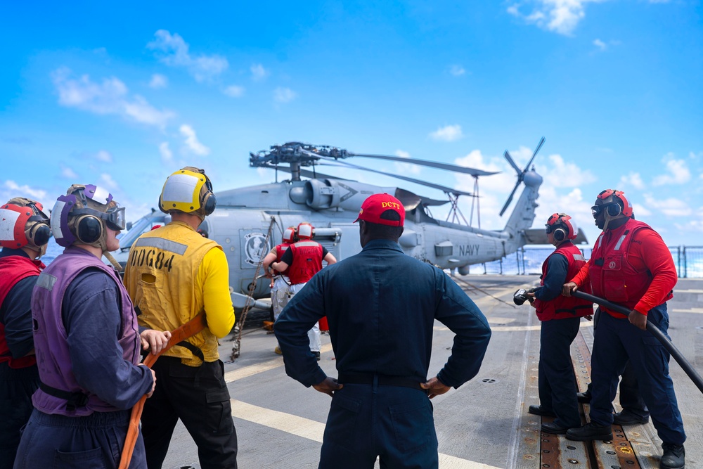 U.S. Navy Sailors man firehoses to respond to a simulated fire